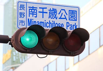 入り口は裏側になります。手前の「南千歳公園」信号を左折してください。